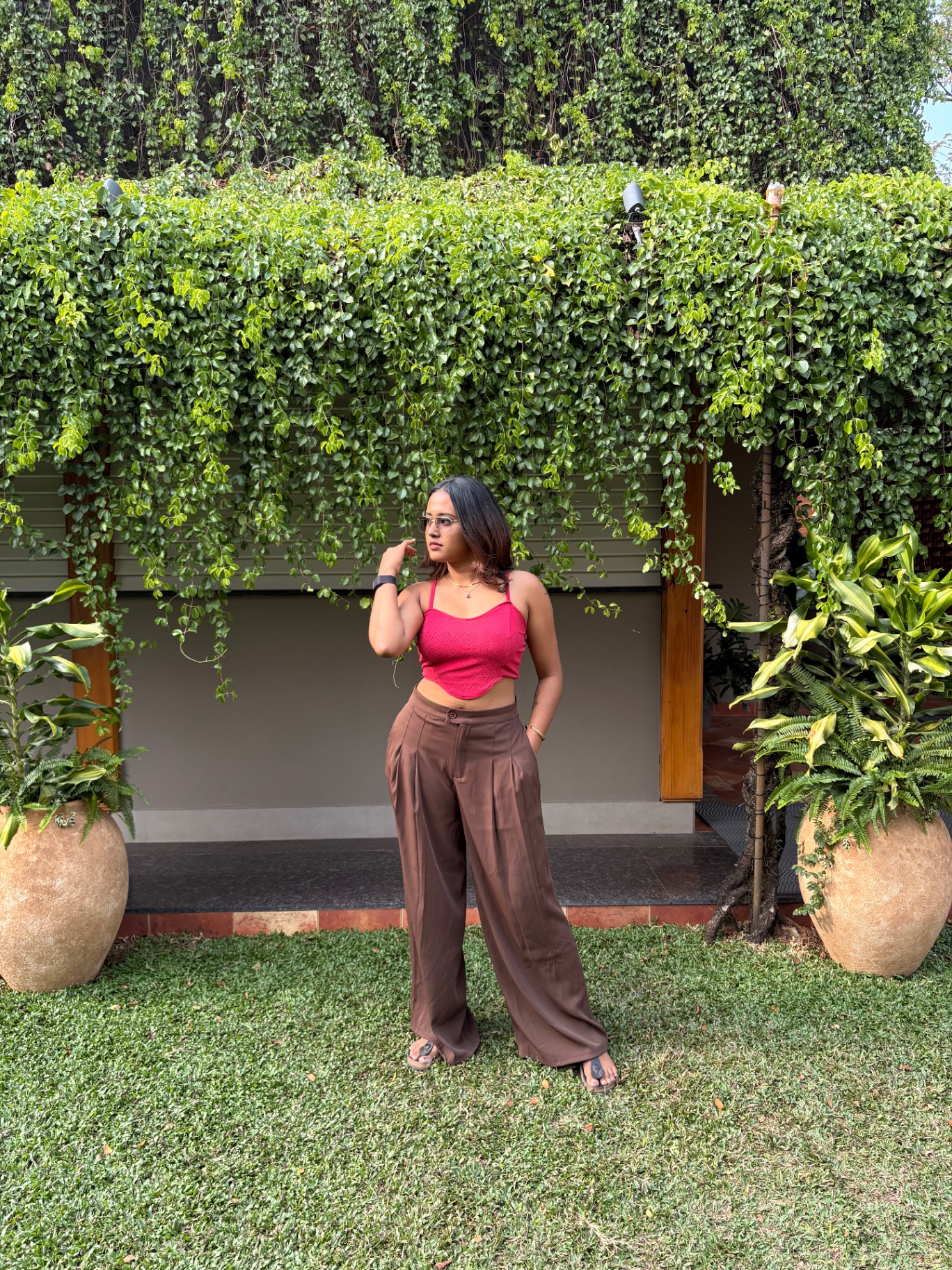 Aswathy in brown trousers in a garden