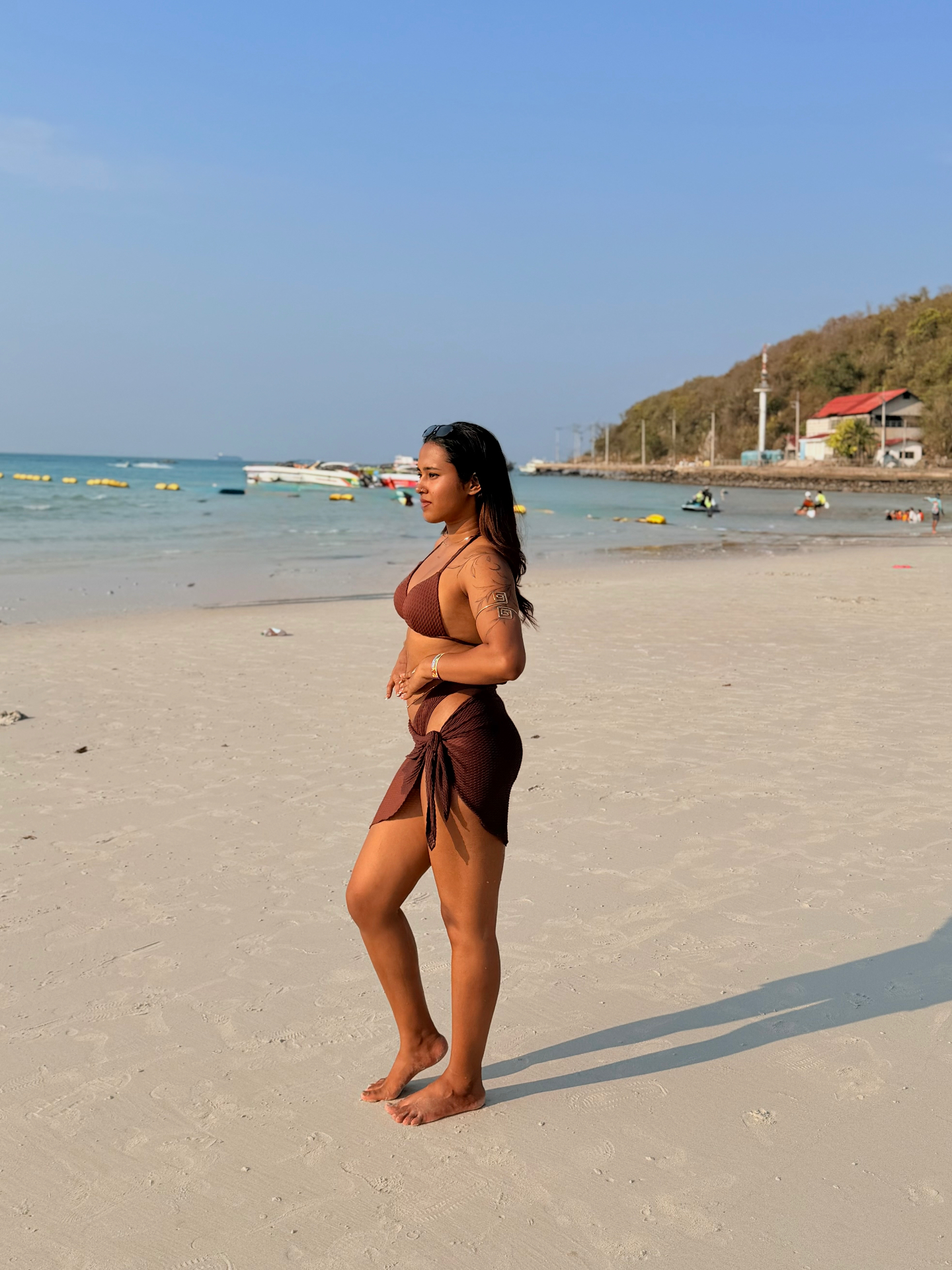 Aswathy on the beach in brown swimwear